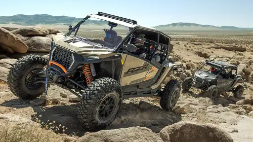 Polaris RZR climbing over rocky terrain