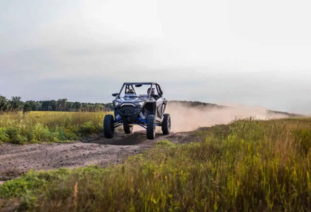 Polaris UTV tearing down a dirt road trail